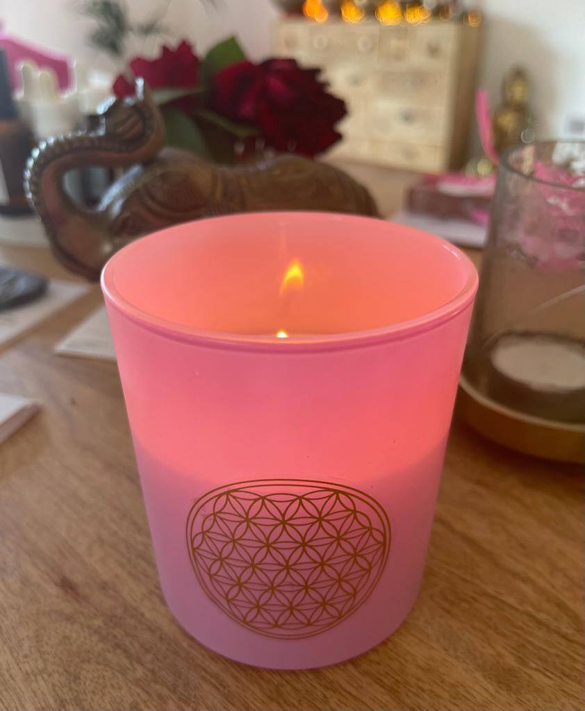 Enciende el amor y la armonía con tu vela Love: tu portal aromático hacia la paz y el bienestar en un frasco de vidrio rosa con tapa de madera.